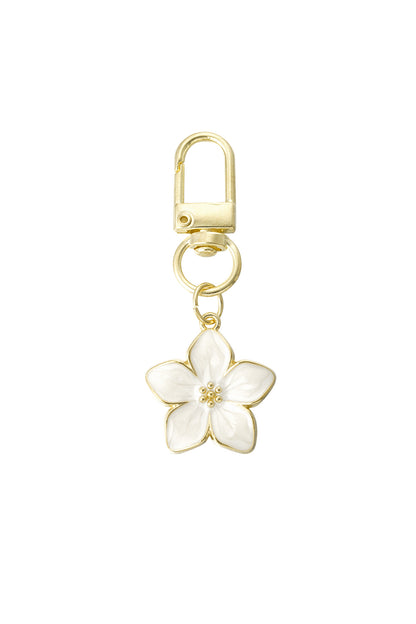 Gold alloy keyring with white enamel blossom flower charm on white background