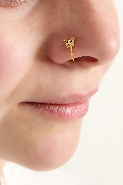 Model wearing gold butterfly nose cuff clipping neatly on her nose, showing youthful and soft aesthetic