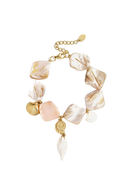 Close-up of seashell charm bracelet with gold accents and adjustable chain on white background