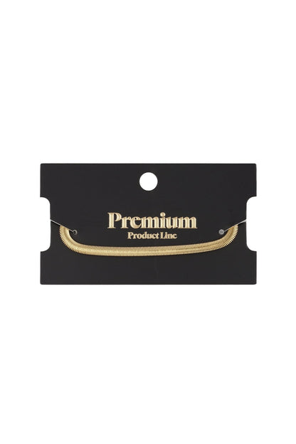 Sleek gold-toned flat herringbone chain bracelet displayed on a black "Premium Product Line" display card.