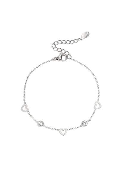 Silver delicate chain bracelet with open heart charms and small clear rhinestones on a white background