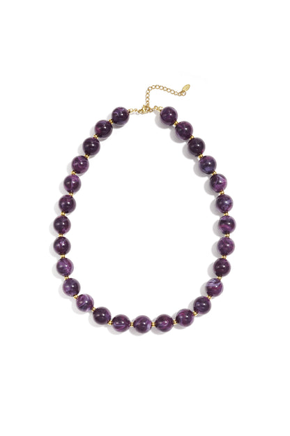 Purple marbled chunky beaded necklace with gold spacer beads and adjustable gold chain on white background