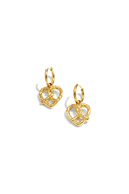 Gold pretzel heart-shaped charm drop earrings with hoop connectors on white background