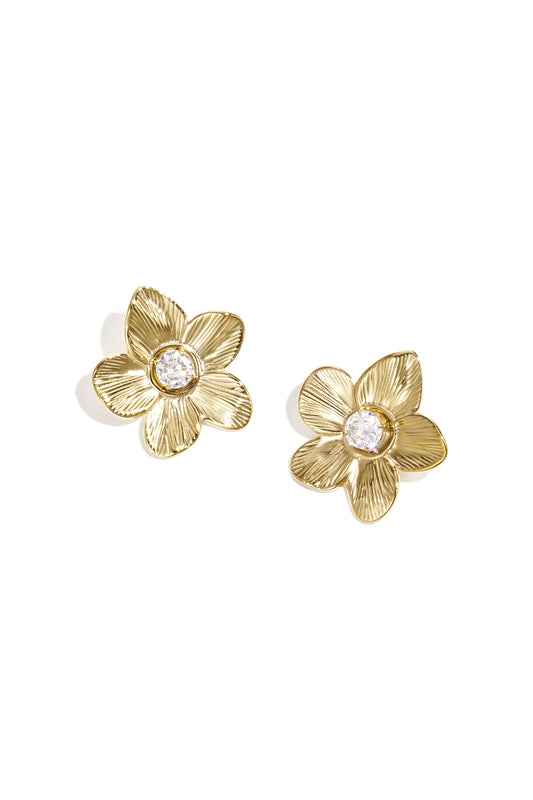 Close-up of gold floral stud earrings with zircon center on white background