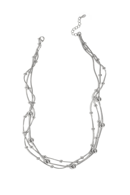 Silver multi-layered necklace with small and large beads laid flat on white background