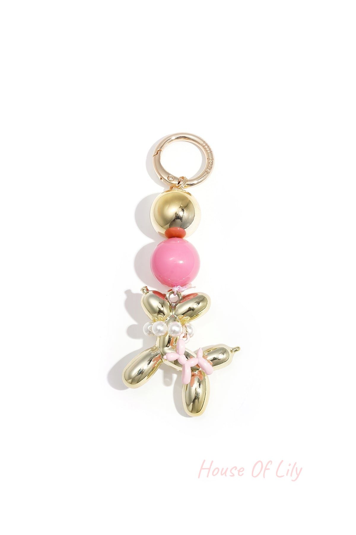 Gold-tone balloon dog keychain with bright pink acrylic bead and pink balloon charm on white background