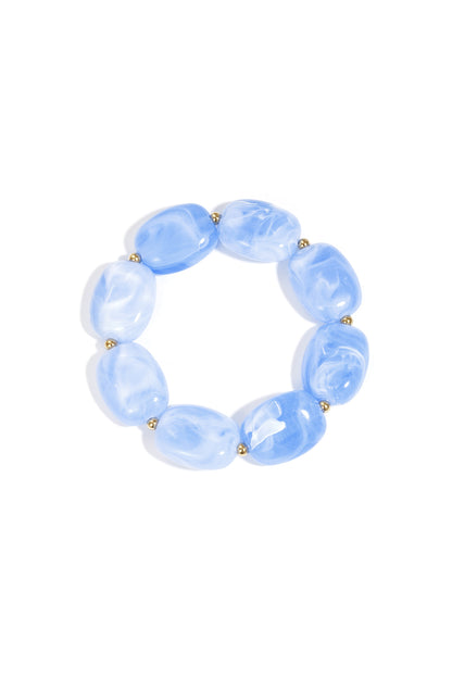 Swirled baby blue acrylic beaded stretch bracelet with gold-toned spacers displayed flat on white background