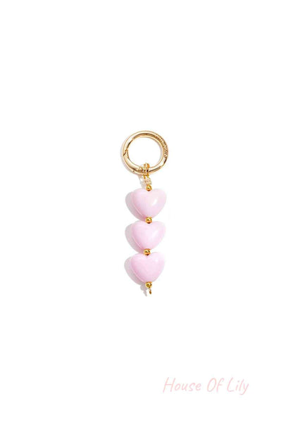 Soft pink acrylic heart charm bag keychain with gold-tone clasp on white background