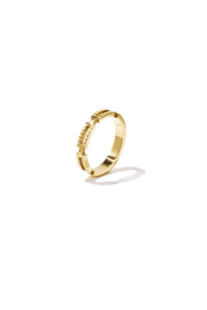Close-up of a geometric textured gold ring on white background