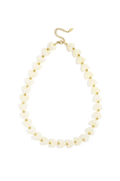 Light pink glossy heart bead necklace with gold spacers on white background