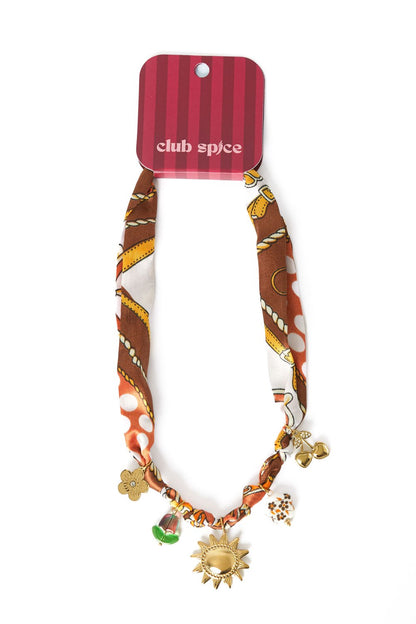 Pattern Heart Era: Brown patterned fabric ribbon necklace with gold-tone sun, cherry, and flower charms.