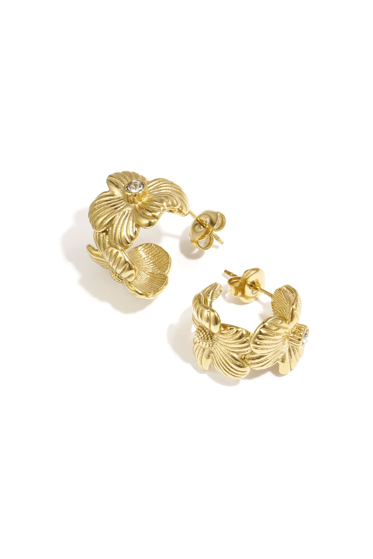 Pair of gold-tone floral hoop earrings with rhinestone center on white background