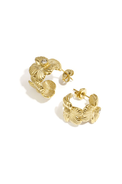 Pair of gold-tone floral hoop earrings with rhinestone center on white background