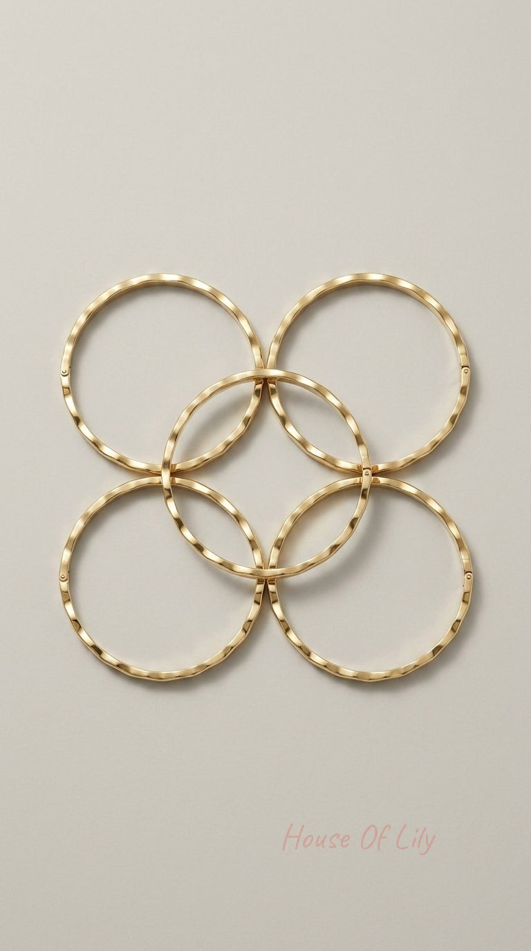 Four gold-plated hoop earrings with a subtle, textured wavy surface arranged in a symmetrical flower pattern.