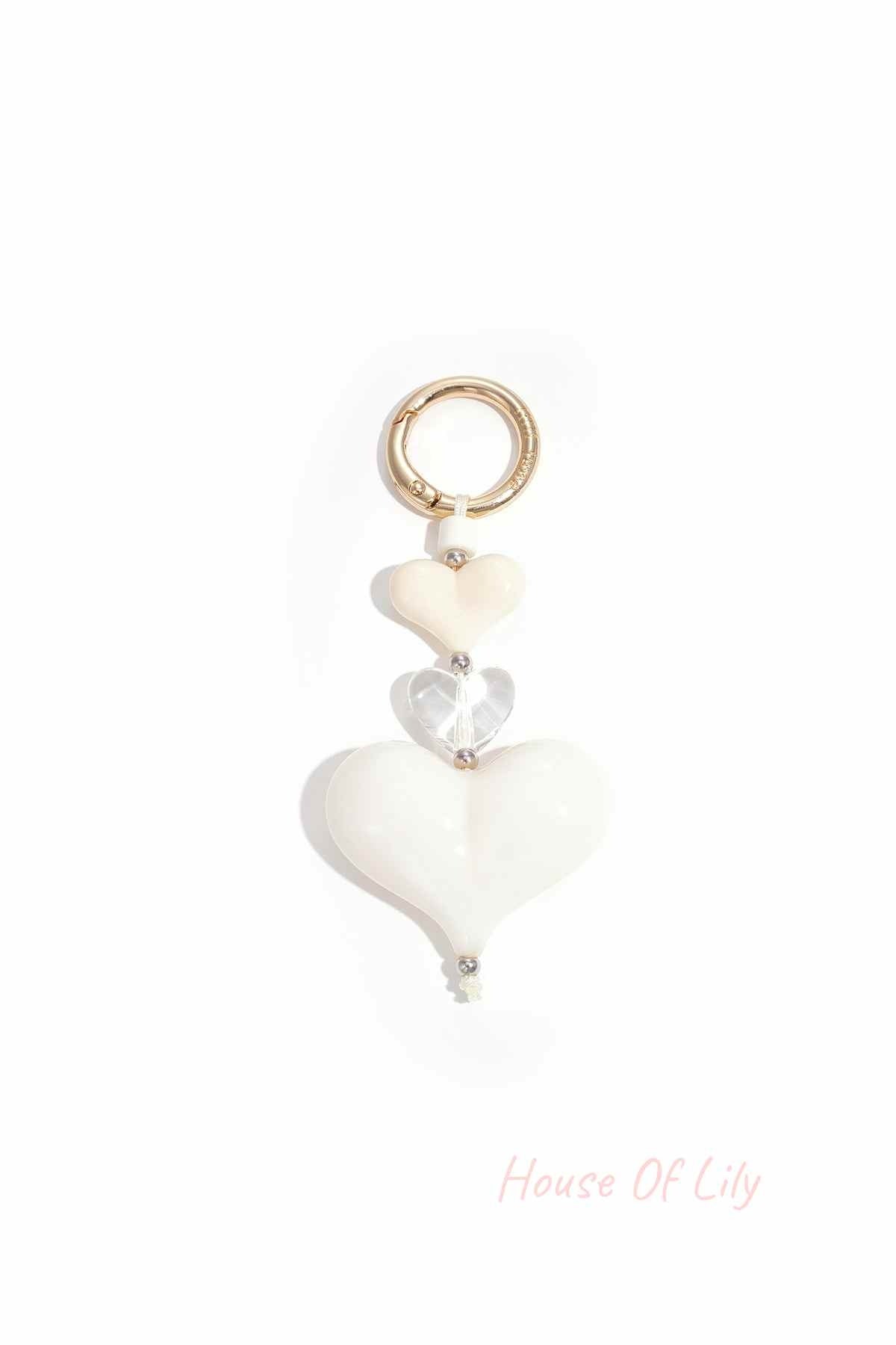 Cream and clear acrylic heart charm keychain with gold-tone clasp on white background