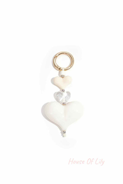 Cream and clear acrylic heart charm keychain with gold-tone clasp on white background
