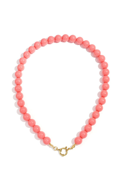 Single strand necklace with glossy light yellow resin beads and gold spring ring clasp on white background