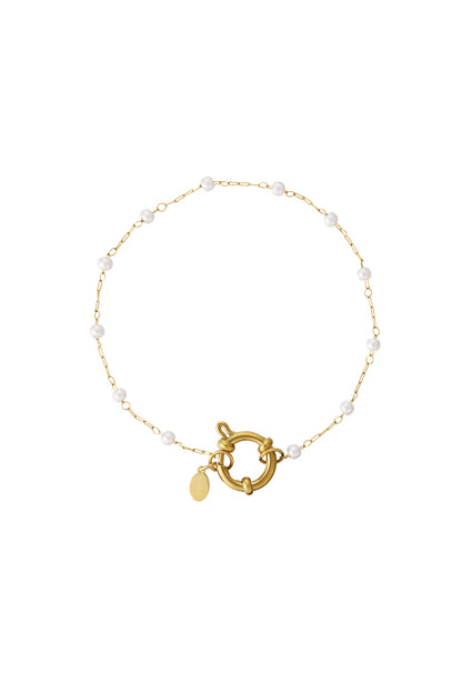 Gold-tone delicate chain bracelet with white pearl beads and oversized toggle clasp on white background