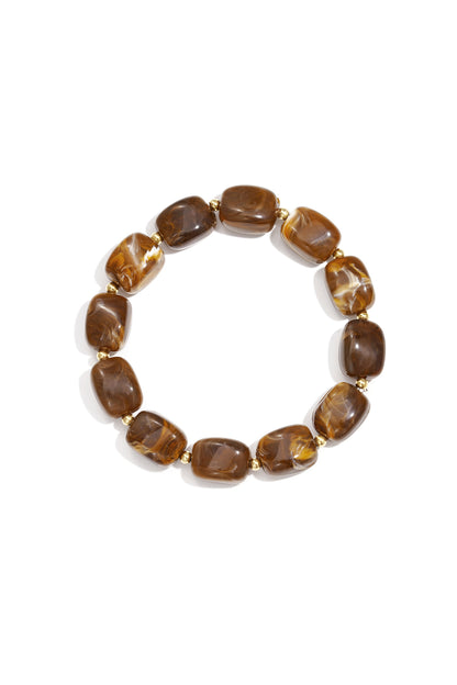 Chocolate brown acrylic chunky bead bracelet with gold spacers on white background