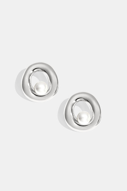 Pair of silver-tone circle stud earrings with pearl centerpiece on white background