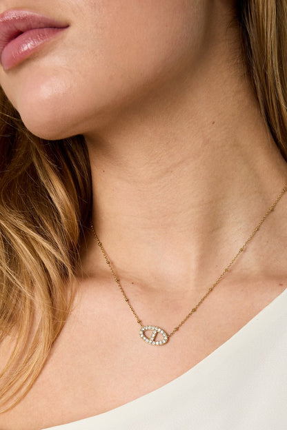 Crystal Main Character gold chain necklace featuring a crystal-paved oval link pendant worn on a model.