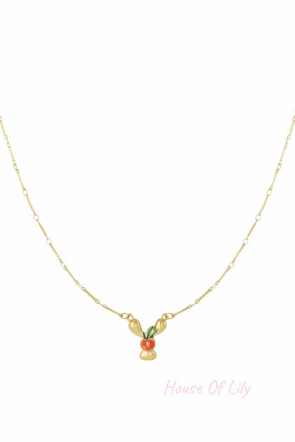 Gold chain necklace featuring a stylized, enamelled orange fruit charm with green leaves on a dainty gold link chain.