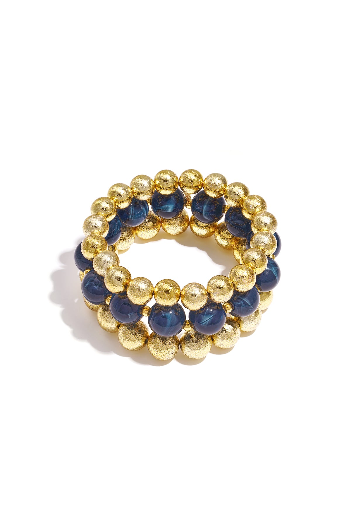 Set of three beaded bracelets with navy blue marbled beads and textured gold spheres on white background