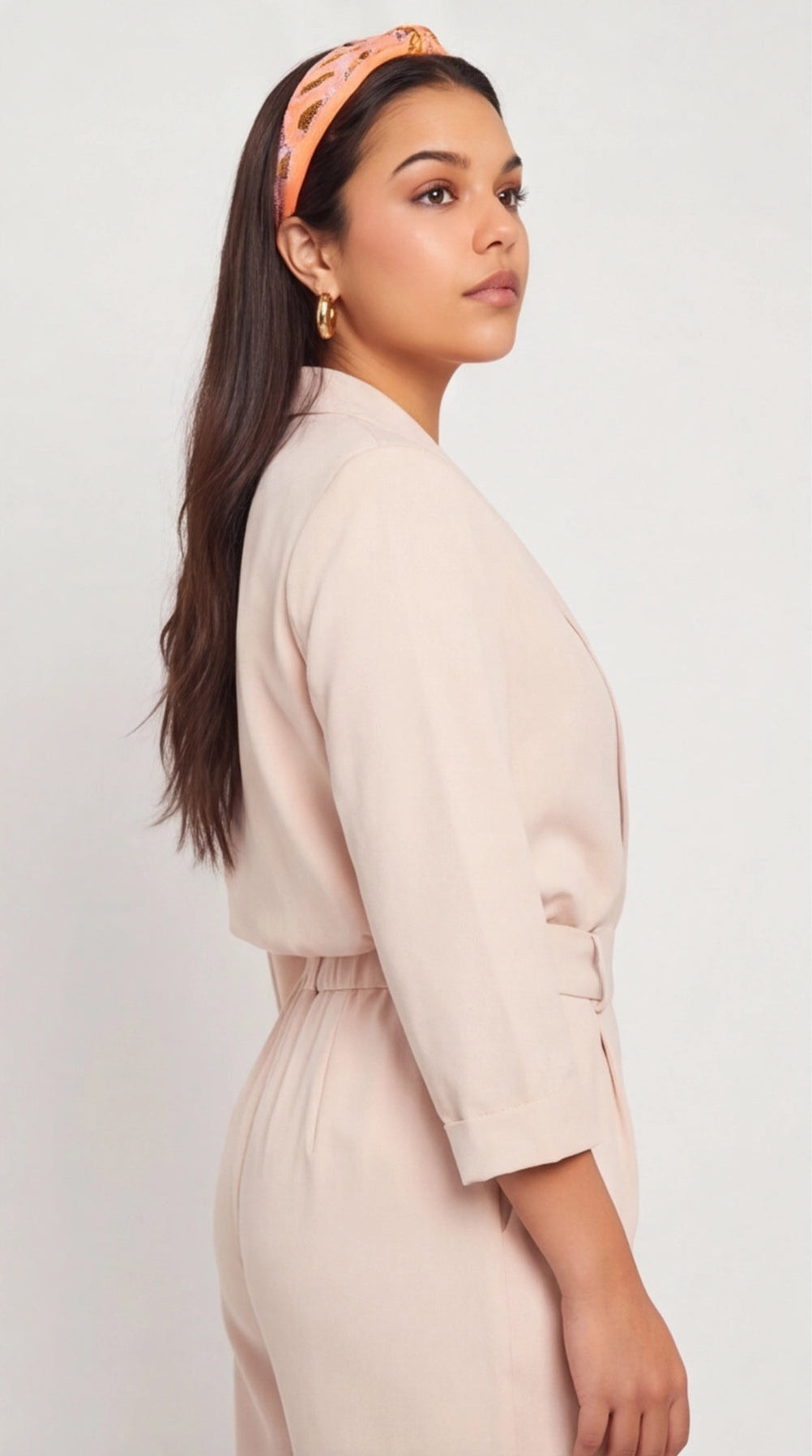 Model wearing polished, thick gold hoop earrings, showcasing a minimalist and classic circular design.