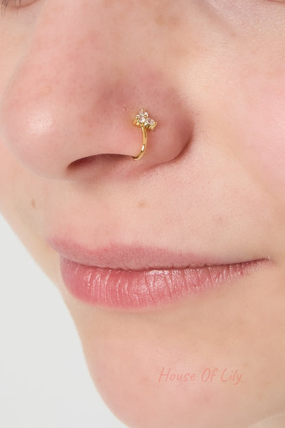 Close-up of a woman's nose wearing the gold nose cuff with three sparkling zircon stones