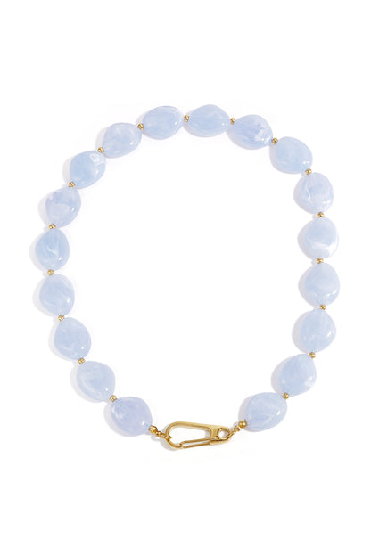 Light blue chunky resin beaded necklace with gold-tone spacers and front clasp shown on white background