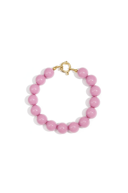 Vibrant pink resin bead bracelet with a gold-toned circular clasp on a white background.