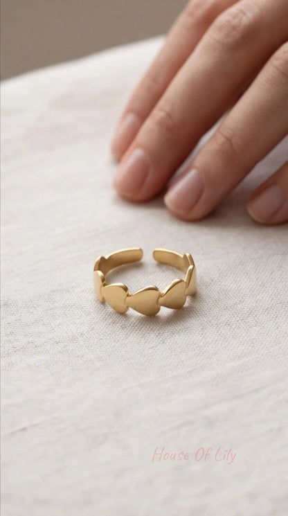 Gold ring on a light fabric surface with a hand in the background