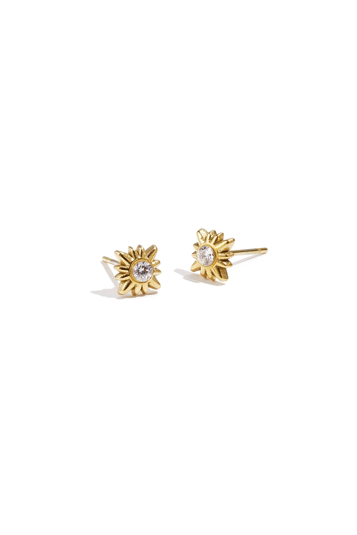 Pair of gold sunburst stud earrings with central clear rhinestones on white background