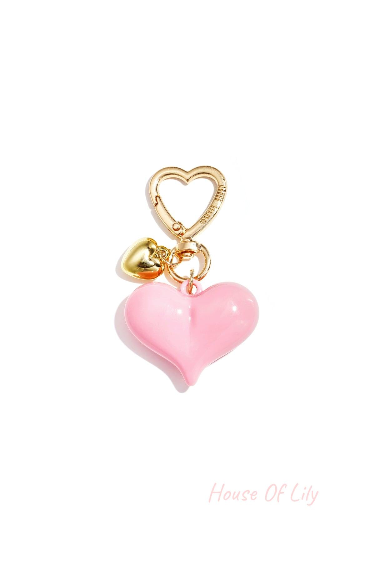 Single light pink acrylic heart bag charm with gold heart clasp and mini gold heart pendant on white background