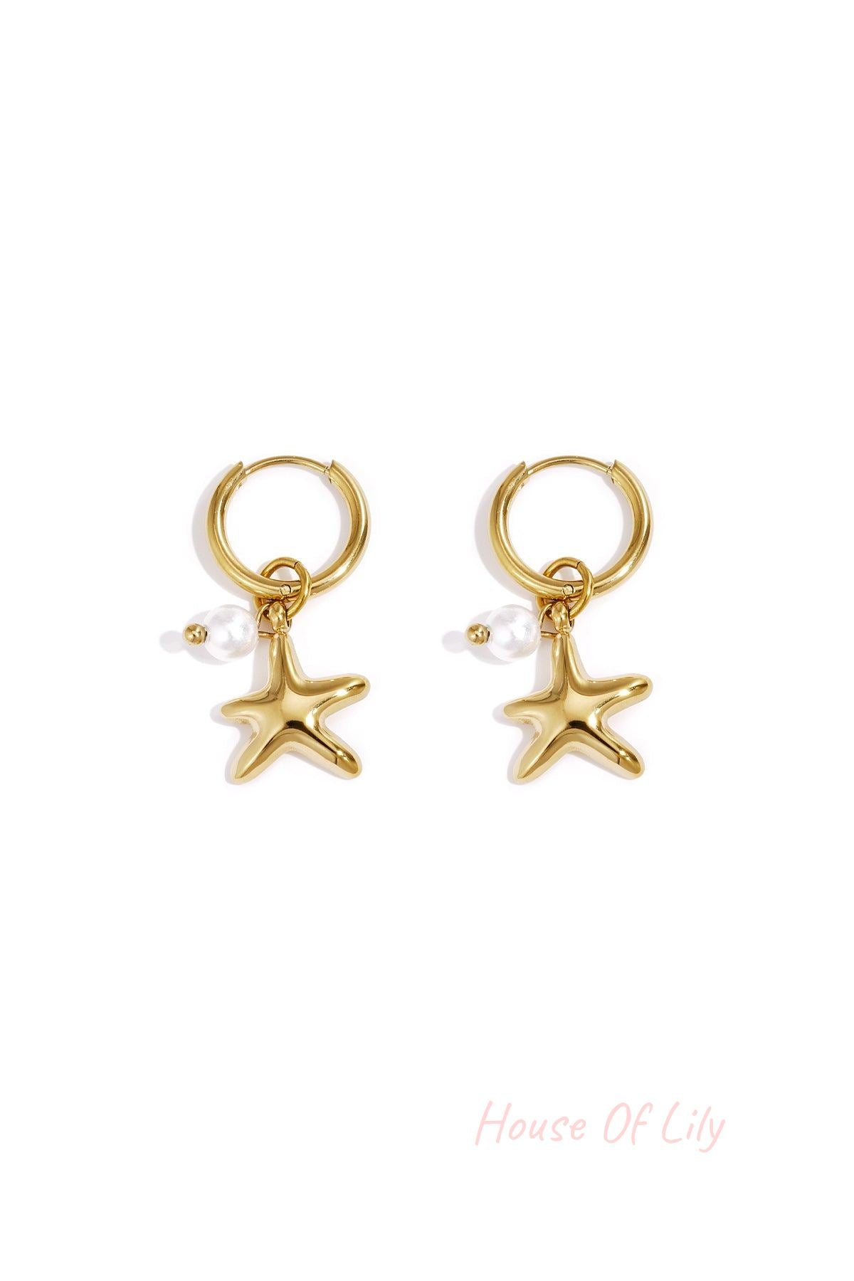 Pair of gold starfish charm hoop earrings with small pearl detail on white background