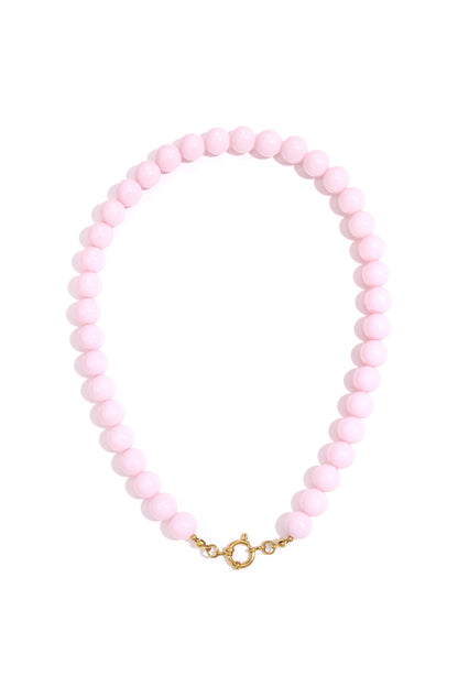 Single strand necklace with glossy coral resin beads and gold spring ring clasp on white background