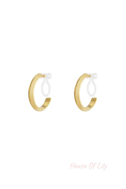 Pair of minimalist 14K gold plated clip-on hoop earrings with smooth rounded design on white background