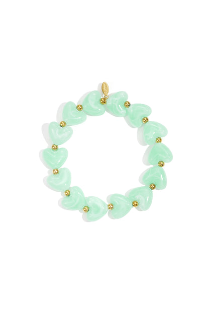 Stretch bracelet featuring mint green heart beads alternating with small gold metallic spacers, isolated on white.