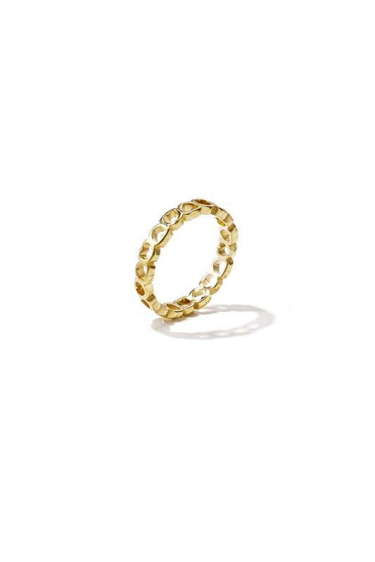 Gold-tone ring with continuous hollow heart shapes on a white background casting a shadow