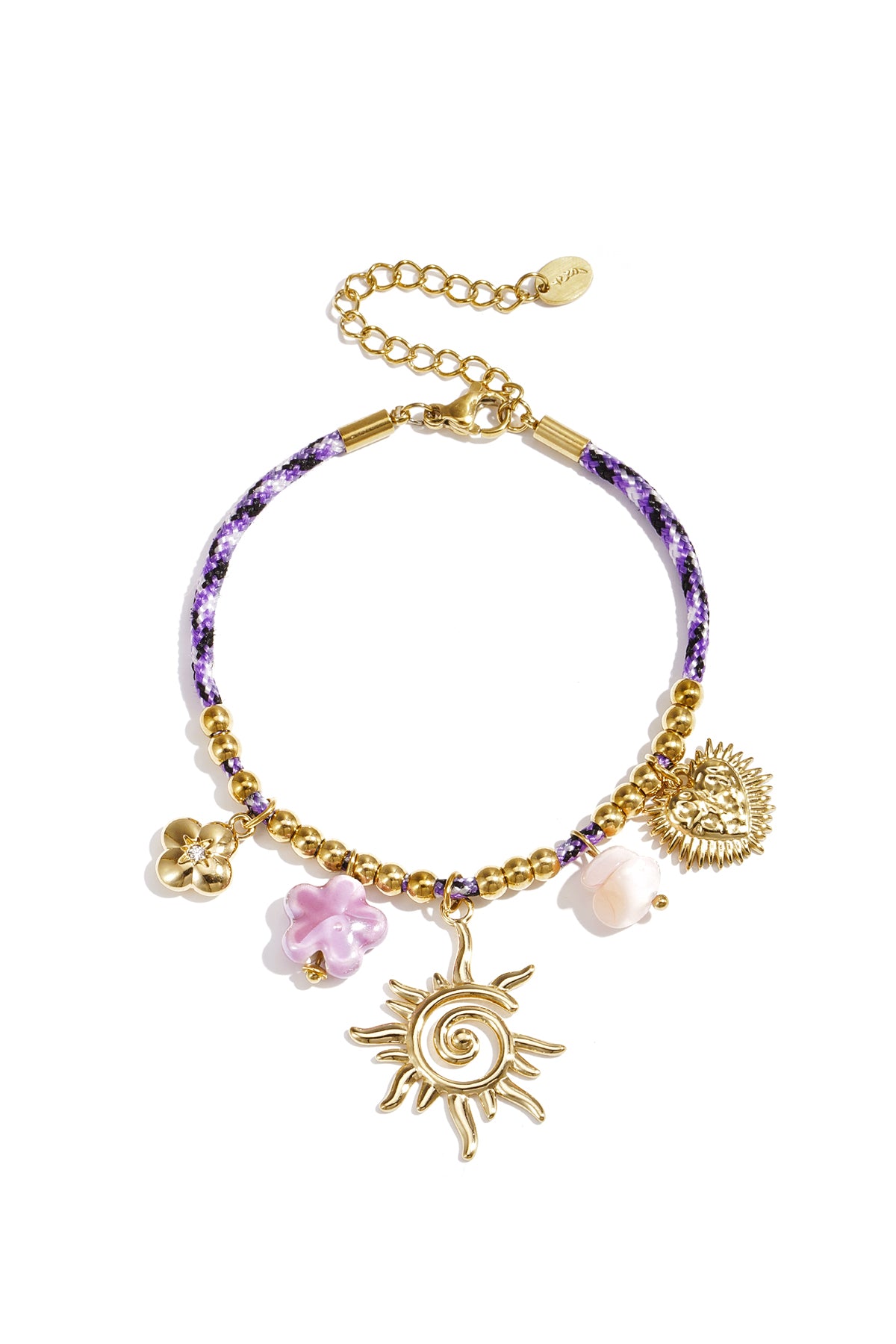Close-up of a purple braided cord charm bracelet with gold beads and assorted charms including a sunburst, flowers, and heart pendant