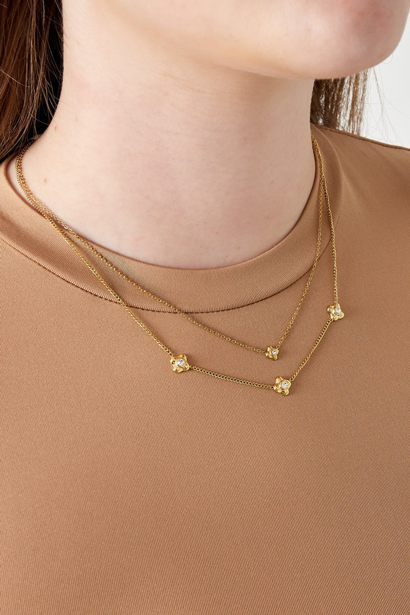 Model wearing the gold tone double layered flower necklace paired with brown top showing soft youthful style