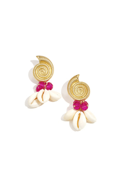 Pair of gold spiral shell drop earrings adorned with bright pink glass beads and white cowry shells on white background