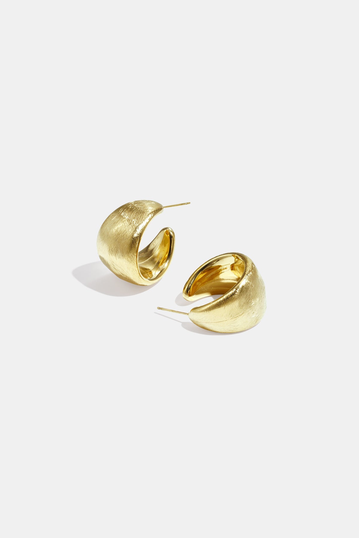 Pair of chunky textured gold hoop earrings on white background