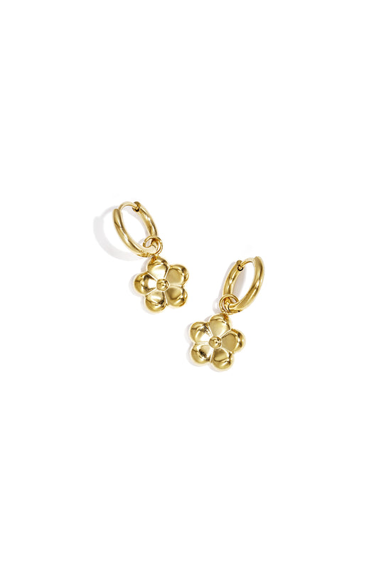 Gold flower pendant hoop earrings displayed on white background