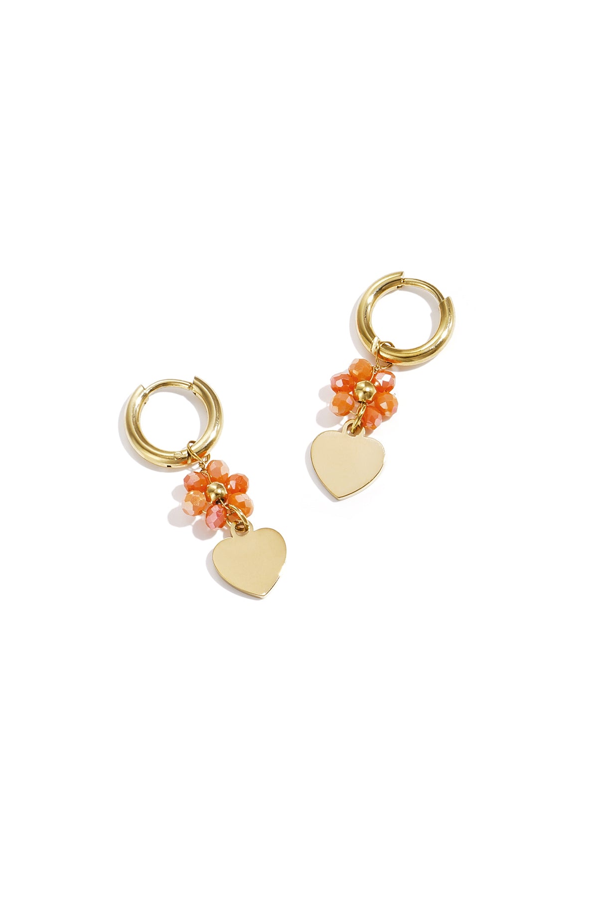 Pair of gold-tone hoop earrings with coral faceted beads and dangling gold heart charms on white background