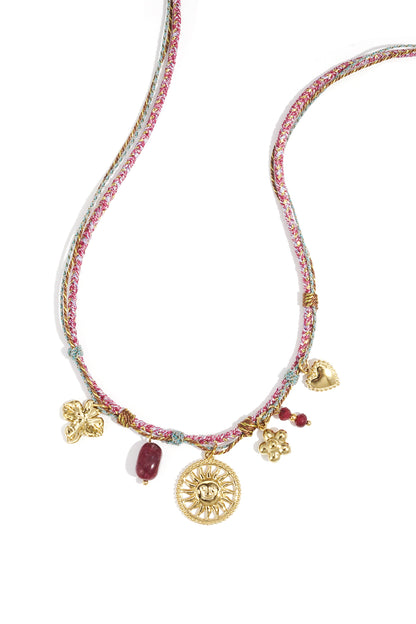 Woven multicolored cord necklace with gold-tone charms including sun, flower, heart, and maroon beads on white background