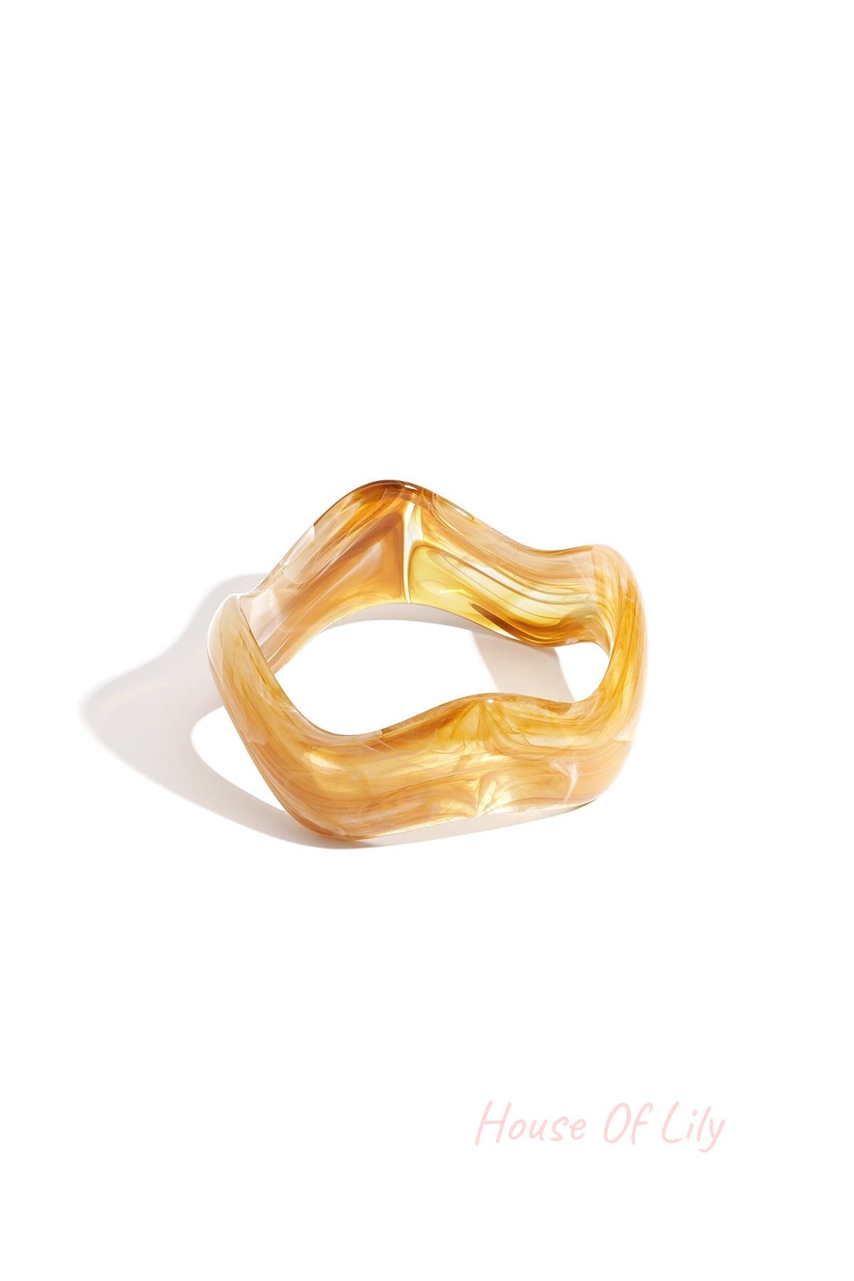 Yellow marbled acrylic bangle with wavy irregular shape on white background