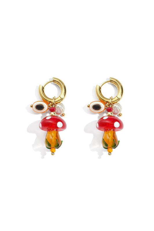 Pair of colorful whimsical mushroom hoop earrings with red and white glass mushroom charms and gold hoops