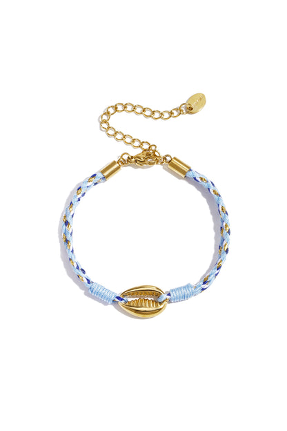 Close-up of braided rope charm bracelet on woman's arm next to gold bead bracelets and other charms seen