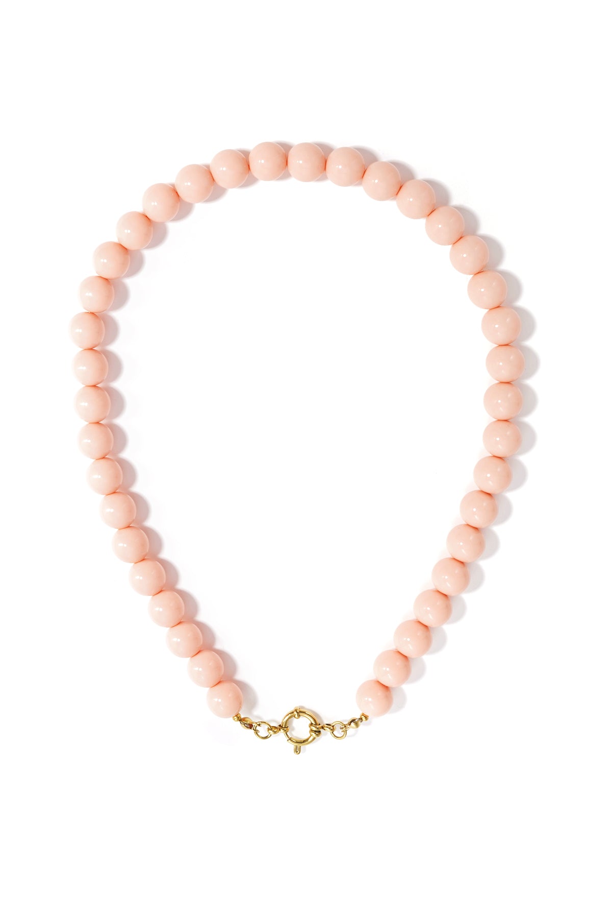 A minimalist necklace of light pink resin beads with a gold-toned circular clasp on a white background.